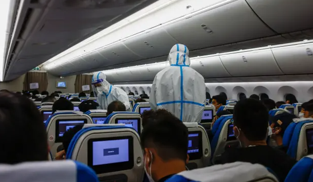 Personeli i linjës ajrore i veshur me kostume mbrojtëse kontrollon pasagjerët me të mbërritur në aeroportin ndërkombëtar Xiamen në provincën Fujian të Kinës, javën e kaluar