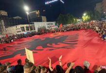 Flamuri gjigant kuqezi me emblemën e UÇK-së shpaloset në protestë